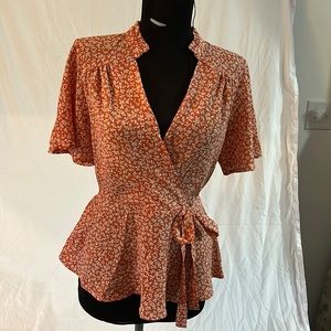 Orange with white floral woman’s blouse size Medium